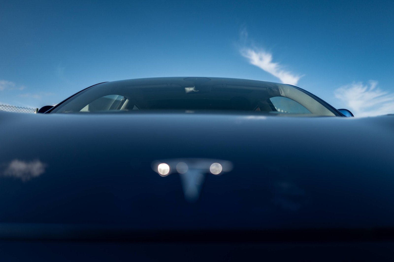 Une voiture électrique bleue reflétant le ciel, commande Byrd Going Electric à Lisbonne.