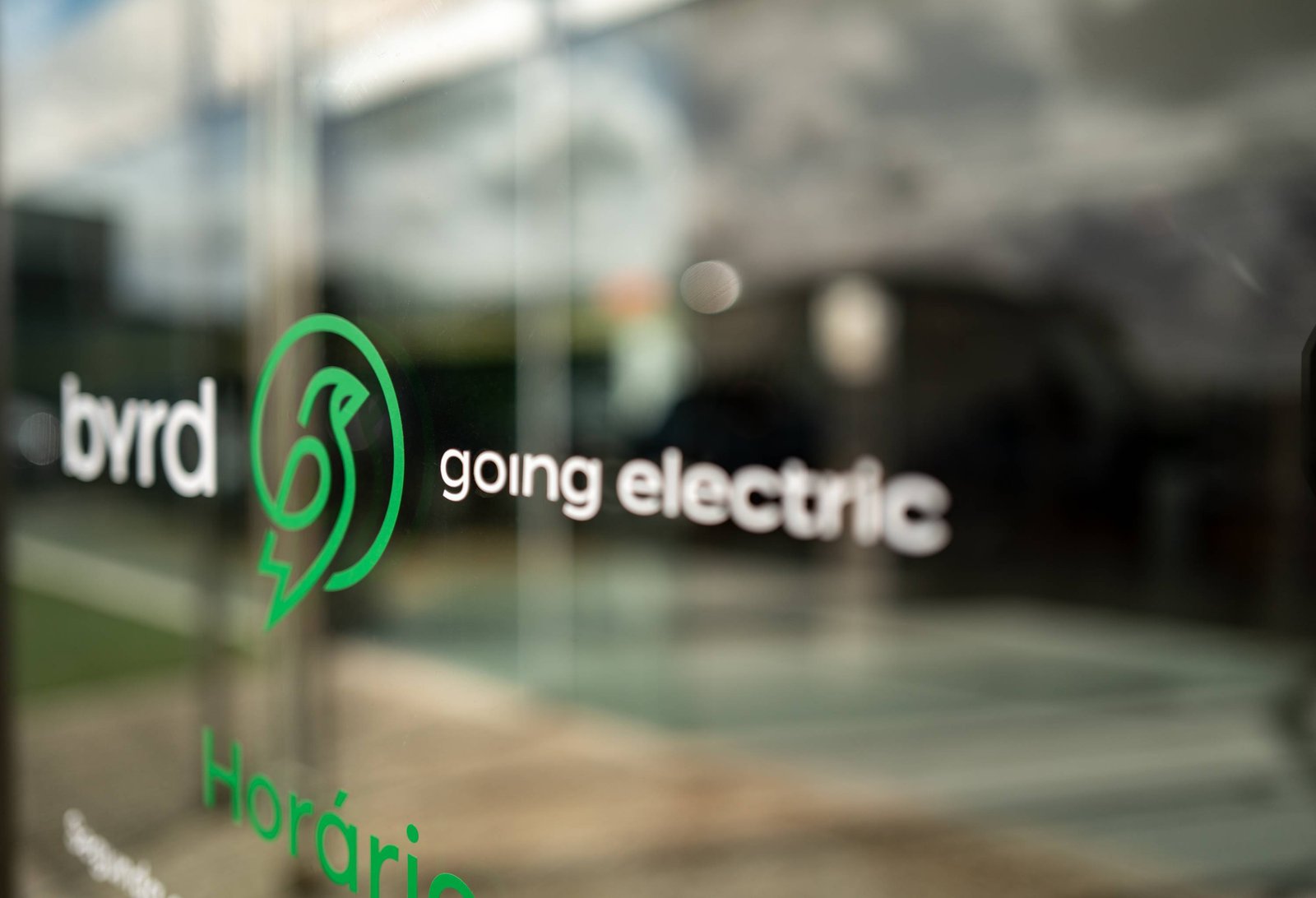 Le logo Byrd Going Electric sur une façade vitrée.