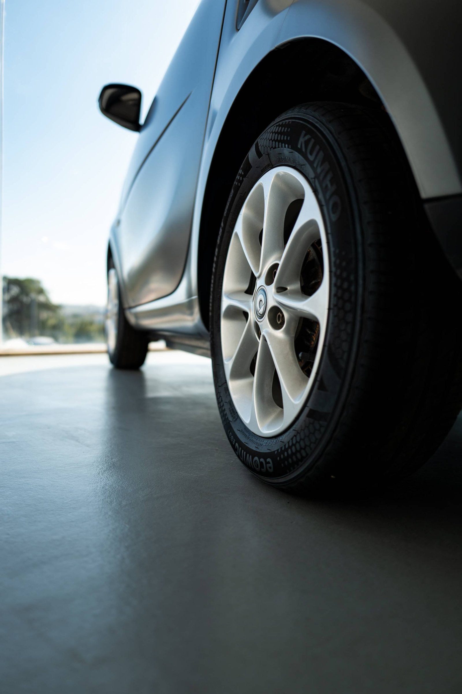 Vue en contre-plongée sur la roue d'une voiture grise.