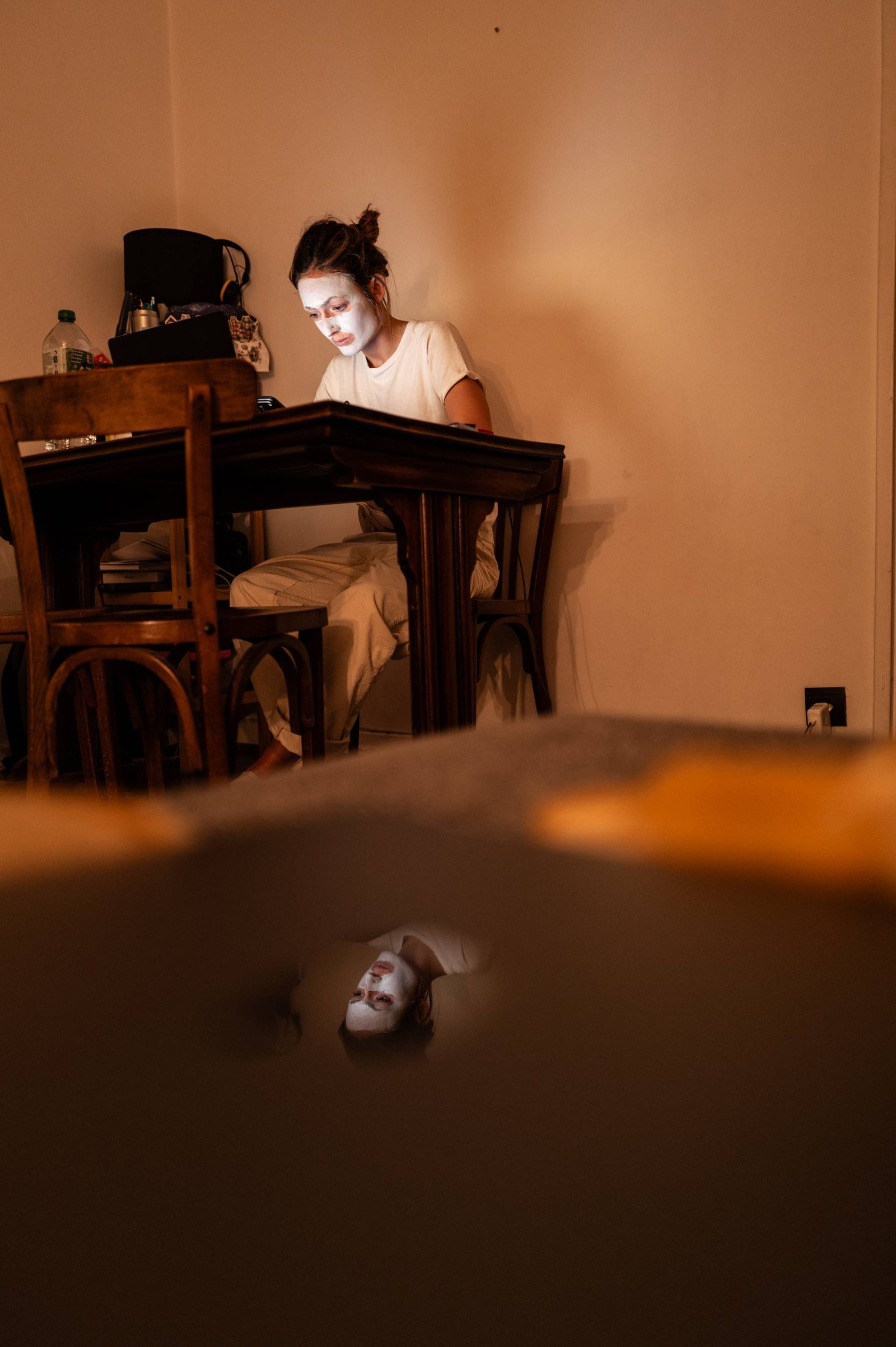 Une personne travaille à une table dans une lumière chaude et basse.