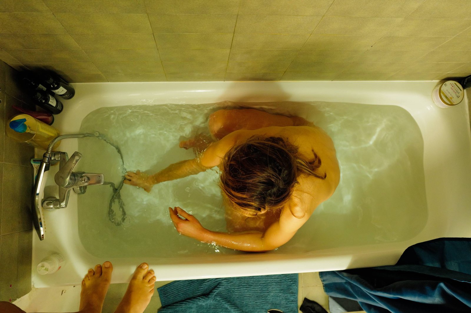 Vue en plongée d'une personne allongée dans une baignoire.